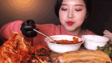 a woman wearing black gloves is eating a bowl of food with a spoon .