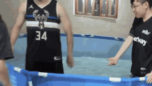 a man in a 34 jersey is standing in a pool