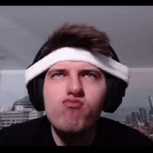 a man wearing headphones and a headband makes a funny face .