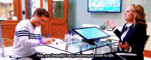 a man and a woman are sitting at a desk and the woman is saying " ann you beautiful sassy mannequin come to life " .