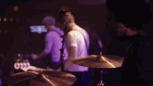 a group of people are on a stage with purple lights