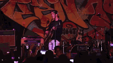 a man is playing a guitar on stage in front of a crowd