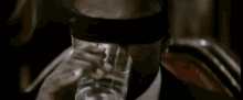 a blindfolded man drinking from a glass