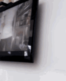 a tv is hanging on a white wall and has a blurry picture on it
