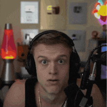 a man wearing headphones and a microphone looks surprised
