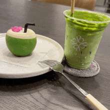 a green cup with bloom written on it sits next to a plate of food