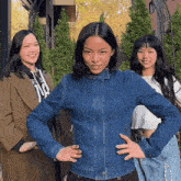 a woman wearing a denim jacket has the number 118 on her sweatshirt