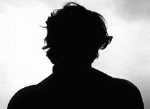 a silhouette of a man 's head with a turtleneck