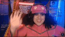 a woman wearing headphones and a pink hat with a sticker on it that says happy halloween