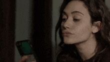 a woman is holding a cell phone in her hand .