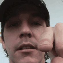 a close up of a man 's face with his finger pointing at the camera