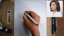 a person is drawing a picture of a woman with a pen .