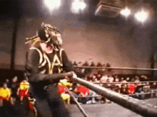 a wrestler in a ring with the letter a on his vest