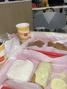 two mcdonald 's cups sit on a table with some food