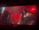 a woman in a cowboy hat stands on a stage in front of a coors sign