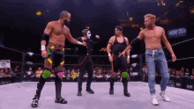 a group of men are standing in a wrestling ring with a sign that says aem on it