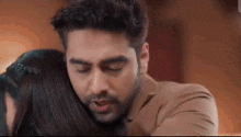 a man is hugging a woman in a close up of his face .