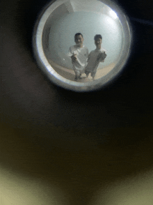 a peephole in a door shows two people standing in a room