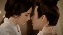 a man and a woman are kissing in front of a mirror .