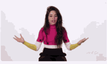 a woman in a pink sweater is sitting with her arms outstretched