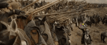 a large group of soldiers are riding horses in a field with spears .