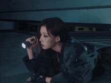 a woman is holding a flashlight and looking through it