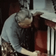 a man in a blue shirt is working on a red table .