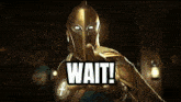 a man in a gold helmet and armor with an ankh on his chest is standing in a dark room .