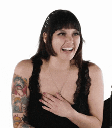 a woman with a tattoo on her arm is smiling and laughing .