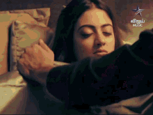 a woman laying on a bed with a star music logo in the corner
