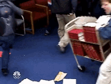 a man is pushing a cart full of red books