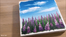 a painting of purple and white flowers on a wooden surface