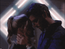 a man and a woman are touching their foreheads in a dark room