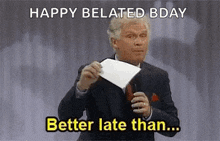 a man in a suit and tie is holding a piece of paper and saying `` happy belated bday better late than ... '' .