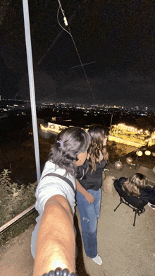 a man and a woman are standing on a balcony at night