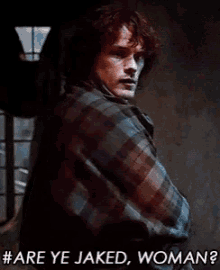 a man in a plaid shirt is standing in front of a window and says #are ye jaked woman ?