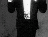 a black and white photo of a man in a tuxedo and tie