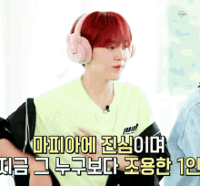 a man with red hair wearing headphones with korean writing on the bottom
