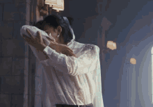 a woman in a white shirt is hugging a man in a white shirt