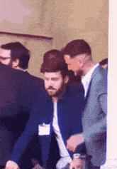 a man in a blue jacket has a name tag on his chest that says ' chris ' on it