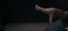 a person 's hand is shown in a blurry photo with a dark background