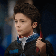 a young boy wearing a jacket with the word wwm on the pocket