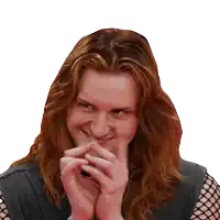 a woman with long red hair is smiling with her hands on her chin