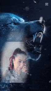 a woman is standing in front of a wolf with its mouth open and teeth showing .