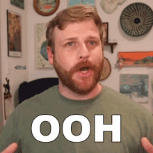 a man with a beard is wearing a green shirt with ooh written on it