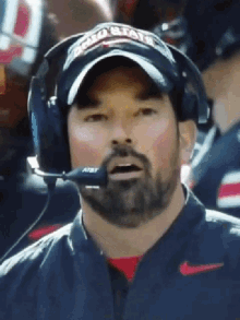 a man wearing a ohio state hat and headphones