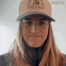 a woman wearing a hat that says duck since 1976