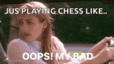 a woman is sitting in a car playing chess and making a face .