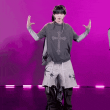 a person with a cross on their shirt is dancing