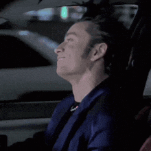 a man with his eyes closed is sitting in a car